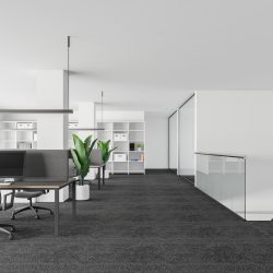 Interior of stylish office with white walls, carpeted floor, rows of computer desks, comfortable bookcase and staircase to the first floor. 3d rendering